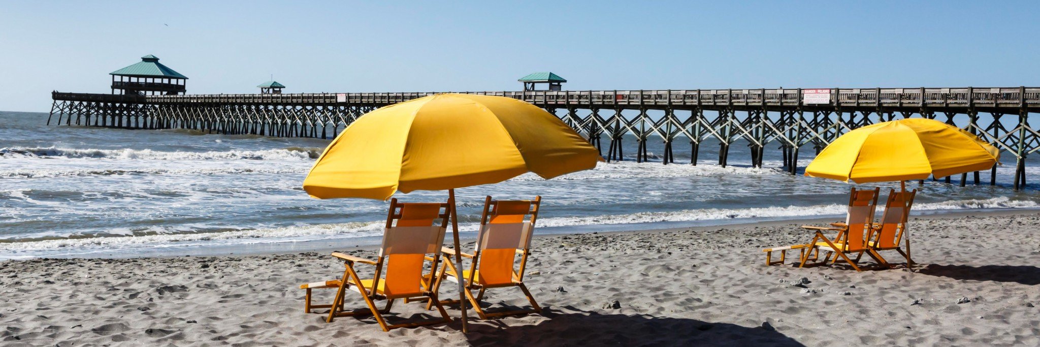 folly beach pier with yellow umbrella