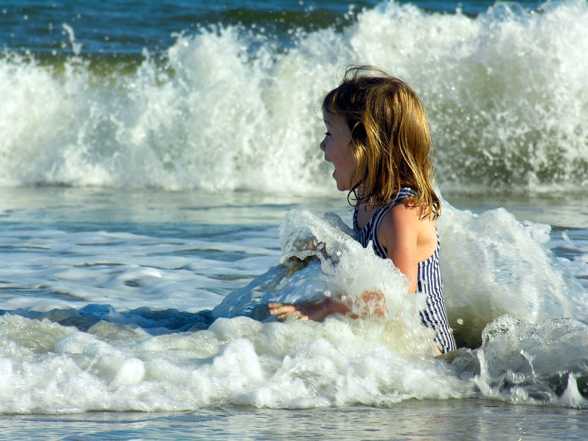 Girl playing in the beachfront ocean waves